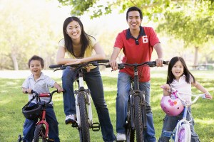 Families On Bikes Outdoors Smiling