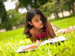Asian Girl Reading A Book In The Park